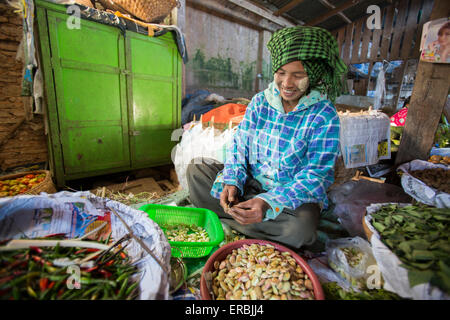 Woman husking beans at market in Yangon Myanmar Stock Photo