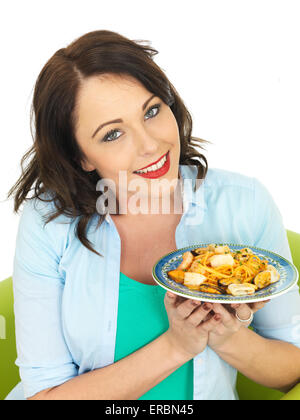 Confident Happy Young Woman Eating Italian Style Seafood Linguine Pasta Meal Isolated Against A White Background With A Clipping Path And Copy Space Stock Photo