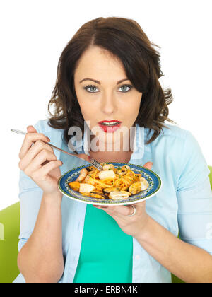 Confident Happy Young Woman Eating Italian Style Seafood Linguine Pasta Meal Isolated Against A White Background With A Clipping Path And Copy Space Stock Photo