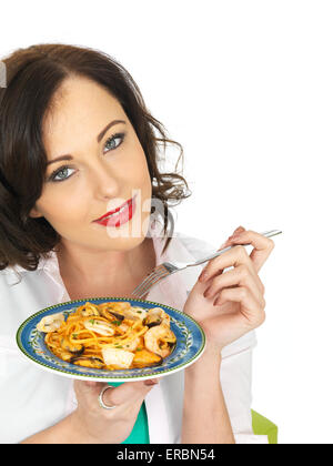 Confident Happy Young Woman Eating Italian Style Seafood Linguine Pasta Meal Isolated Against A White Background With A Clipping Path And Copy Space Stock Photo