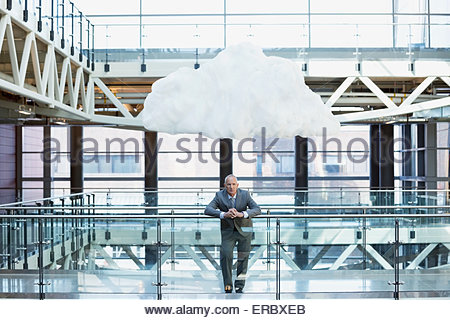 Portrait businessman with cloud overhead on atrium balcony