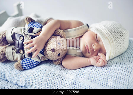 Newborn child sleeping with a teddy bear toy Stock Photo