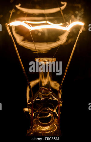 Incandescent electric light bulb filament, turned on. Stock Photo