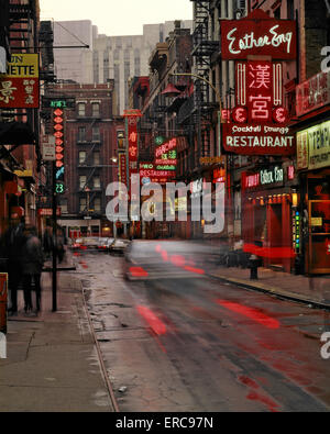 1970s BLUR MOTION CAR TRAFFIC AND NEON SIGNS IN CHINATOWN ALONG DOYERS & PELL STREETS MANHATTAN NEW YORK CITY USA Stock Photo