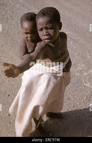 1980s CHILDREN BEGGING FOR FOOD IN AFRICA Stock Photo