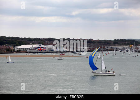 Yachts sail past Venture Quays in Cowes on the Isle of Wight which has the world's largest Union Flag painted on the doors Stock Photo