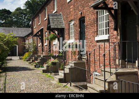 UK, England, Cheshire, Styal, Oak Cottages and gardens, terrace of mill workers houses leading to village school Stock Photo