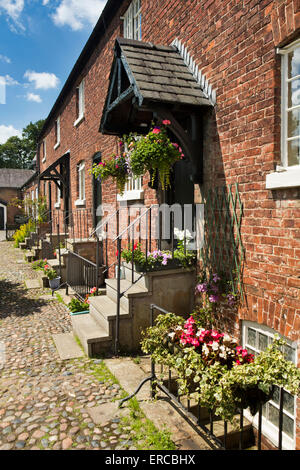 UK, England, Cheshire, Styal, Oak Cottages and gardens, terrace of mill workers houses leading to village school Stock Photo