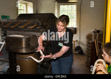 UK, England, Cheshire, Styal, Quarry Bank Mill, Textile Interpreter showing carding machine at work Stock Photo