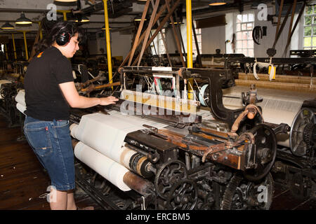 UK, England, Cheshire, Styal, Quarry Bank Mill, workers operating loom making cotton cloth Stock Photo