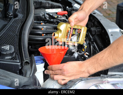Pouring radiator leak repair liquid into a cars cooling system Stock