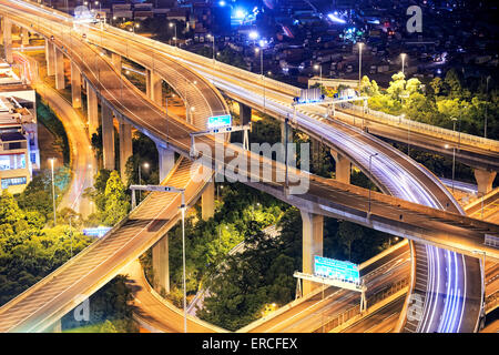 Highway traffic, light trails on the modern building background in Hong Kong Stock Photo