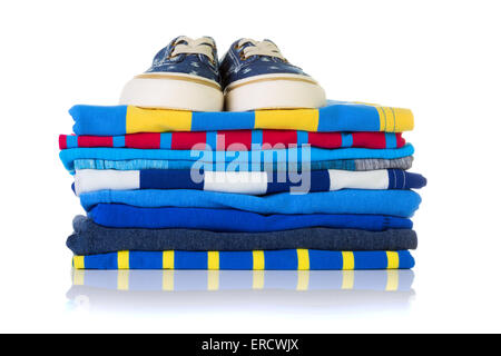 Stack of colourful summer shirts and a pair of sneakers on top isolated on white background Stock Photo