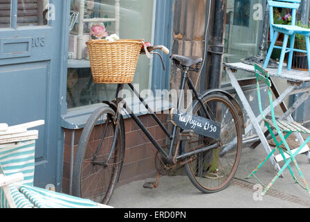 Documentary image of an old bicycle outside of a vintage shop advertising teas and coffee's in Matlock Derbyshire. Stock Photo