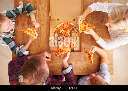 Family eating pizza together, overhead view Stock Photo