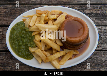 Suet meat pudding, mushy peas, chips and gravy Stock Photo