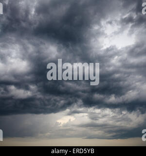 heavy low storm clouds in evening spring sky Stock Photo