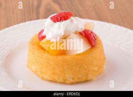 Dessert shell with fruit cocktail and whipped cream topping on a white plate Stock Photo