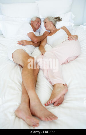 Mature couple lying in bed having relationship problems Stock Photo - Alamy
