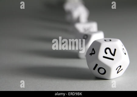 A regular white dodecahedron dice with several other Platonic solid dice on the background Stock Photo