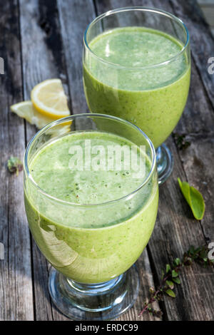Green vegetable smoothies in two glasses on rustic wooden background Stock Photo