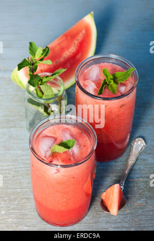 Fresh watermelon slush frozen drinks in two glasses on blue rustic wooden background Stock Photo
