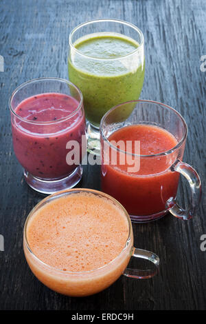 Fresh assorted fruit and vegetable smoothies on rustic wooden background Stock Photo