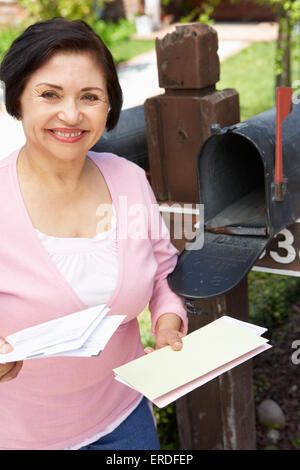 Senior Hispanic Woman Checking Mailbox Stock Photo