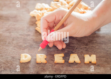 Dream alphabet biscuit on wooden table, stock photo Stock Photo