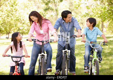 Asian family riding bikes in park Stock Photo