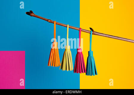 Brightly colored leather tassels on block color background Stock Photo