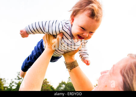 Caucasian mother playing with baby girl outdoors Stock Photo