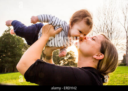 Caucasian mother kissing baby girl outdoors Stock Photo