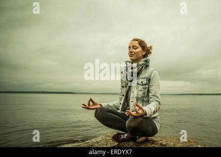 Caucasian woman meditating near ocean