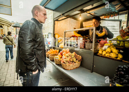 Caucasian man buying produce at fruit kiosk Stock Photo