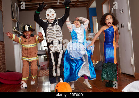 Children in Halloween costumes jumping for joy Stock Photo