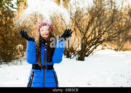 Caucasian girl throwing snow field Stock Photo
