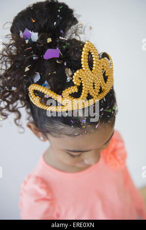 Mixed race girl wearing tiara and confetti Stock Photo