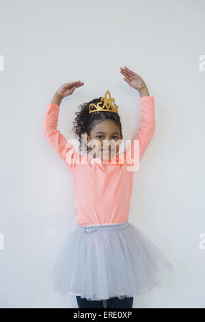 Smiling mixed race ballerina posing in tiara Stock Photo