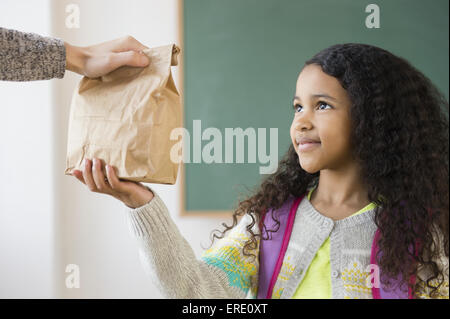 Student taking brown bag lunch in classroom Stock Photo