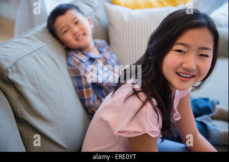 Asian brother and sister relaxing on sofa Stock Photo