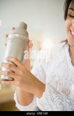 Pacific Islander woman shaking cocktail shaker Stock Photo