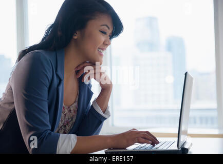 Pacific Islander businesswoman using laptop in office Stock Photo