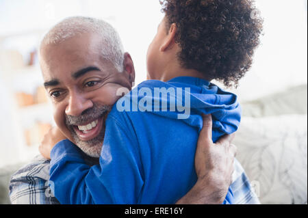 Close up of mixed race grandfather and grandson hugging Stock Photo