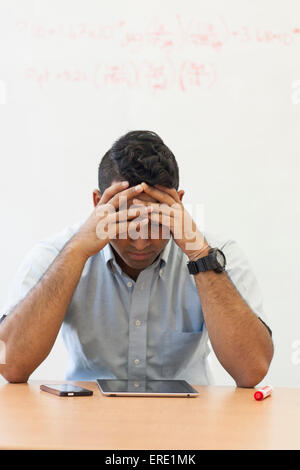 Frustrated Asian businessman with digital tablet and cell phone Stock Photo