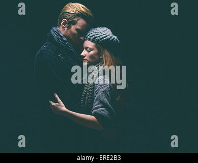 Couple wearing warm clothing hugging Stock Photo