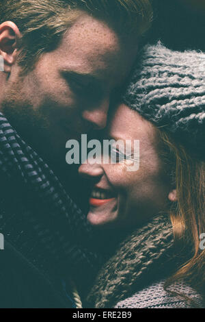 Smiling couple wearing warm clothing hugging Stock Photo