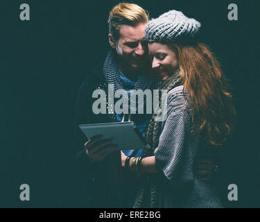 Couple wearing warm clothing using digital tablet Stock Photo