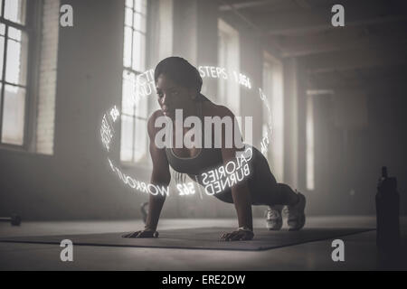 Virtual words circling Black athlete doing push-ups Stock Photo