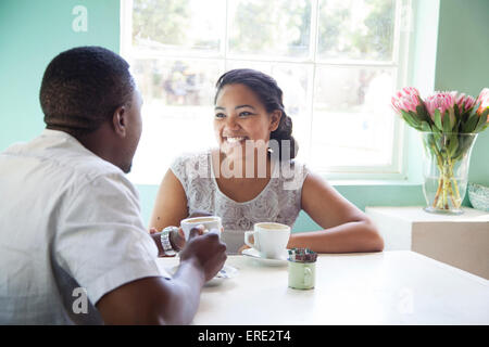 Smiling couple drinking coffee at table Stock Photo